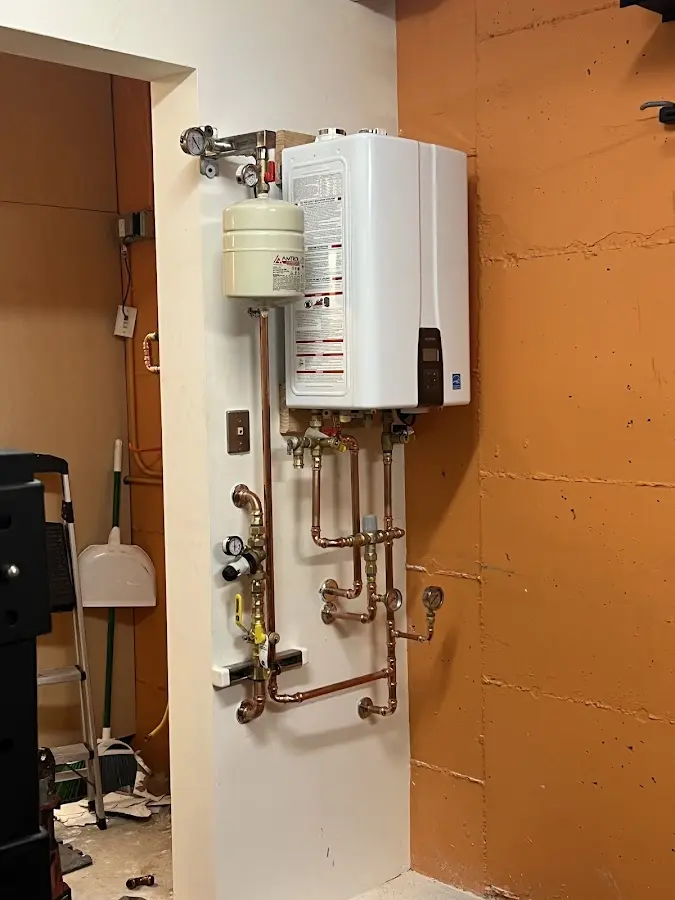 Plumbing technician inspecting water heater connections in Kittanning